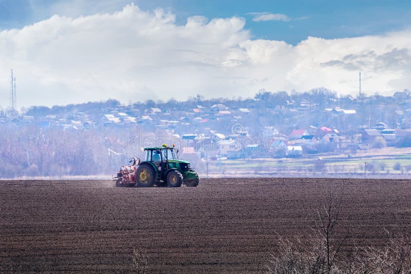 Ukraine, Khmelnytsky region, March 2021. Tractor with a seeder in the field during sowing of grain