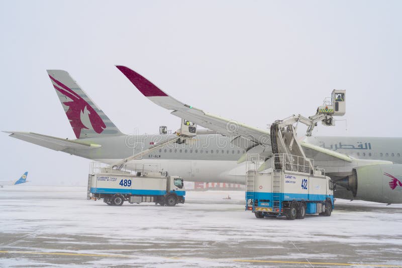 Ukraine, Kyiv - February 12, 2021: De-icing the aircraft before the flight. The deicing machine sprinkles the wing of a passenger