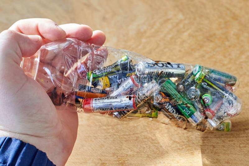 Ukraine, Shostka -March 20, 2019: A man holds a plastic bottle with used batteries, the topic of sorting garbage stock photo Ukraine, Shostka -March 20, 2019: A man holds a plastic bottle with used batteries, the topic of sorting garbage stock photo