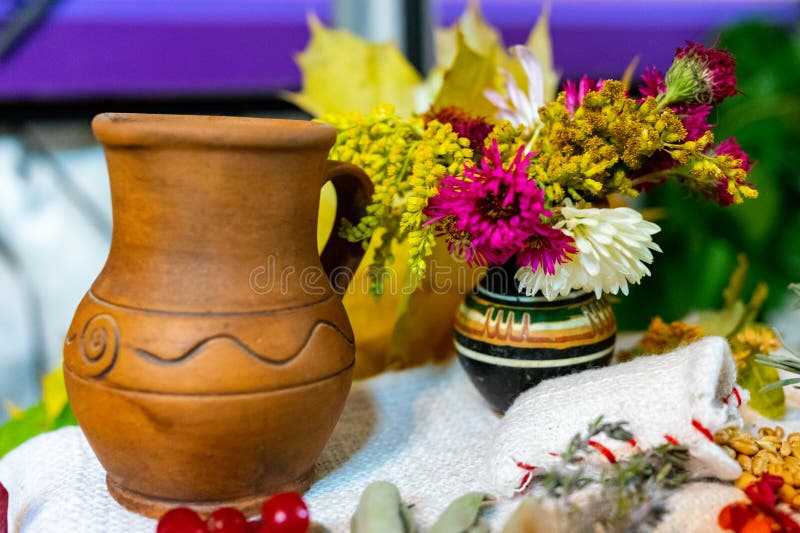 Ukrainian clay milk jug and flowers in a vase stock image