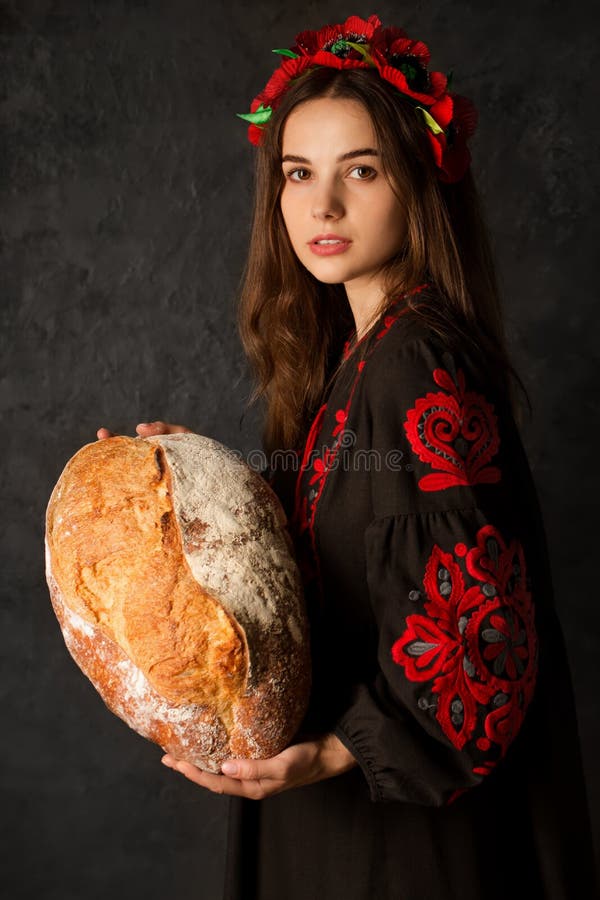 A Ukrainian woman holds a palyanitsa in her hands