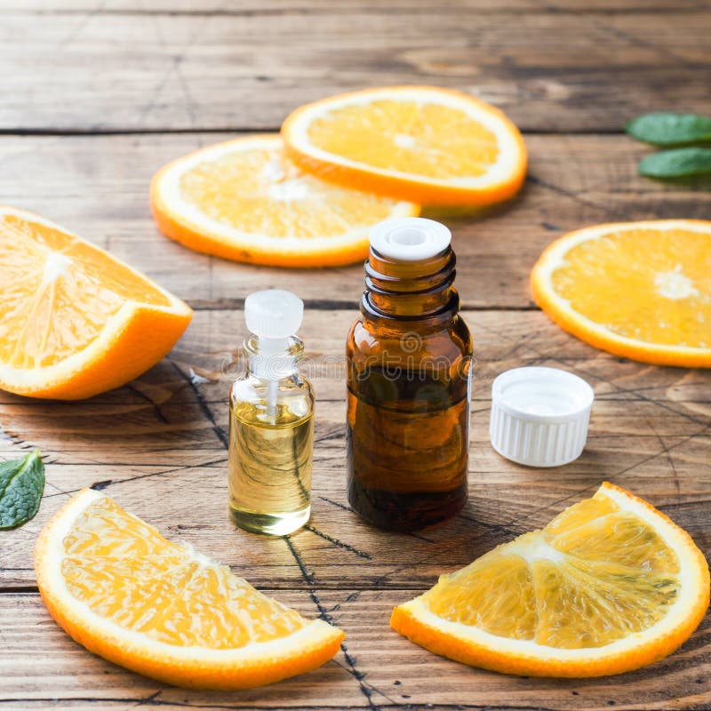 Ulei de portocale esențial în butelii feliate de fructe proaspete pe fond de lemn. parfumuri naturale stock photos
