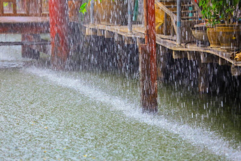 Ulewny Deszcz kropla w wodzie z rocznika drewnianym domem na kanale