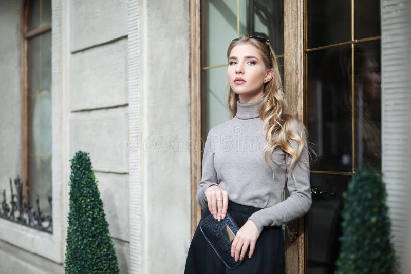 Uliczny mody pojęcie: portret elegancka młoda piękna kobieta pozuje blisko drzwi Talia up tła piękna miasta styl życia miastowi k obraz royalty free Uliczny mody pojęcie: portret elegancka młoda piękna kobieta pozuje blisko drzwi Talia up tła piękna miasta styl życia miastowi k obraz royalty free