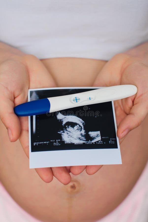 Ultraljudbild- och realitetgraviditetstest i händerna av en gravid flicka royaltyfria bilder Ultraljudbild- och realitetgraviditetstest i händerna av en gravid flicka royaltyfria bilder