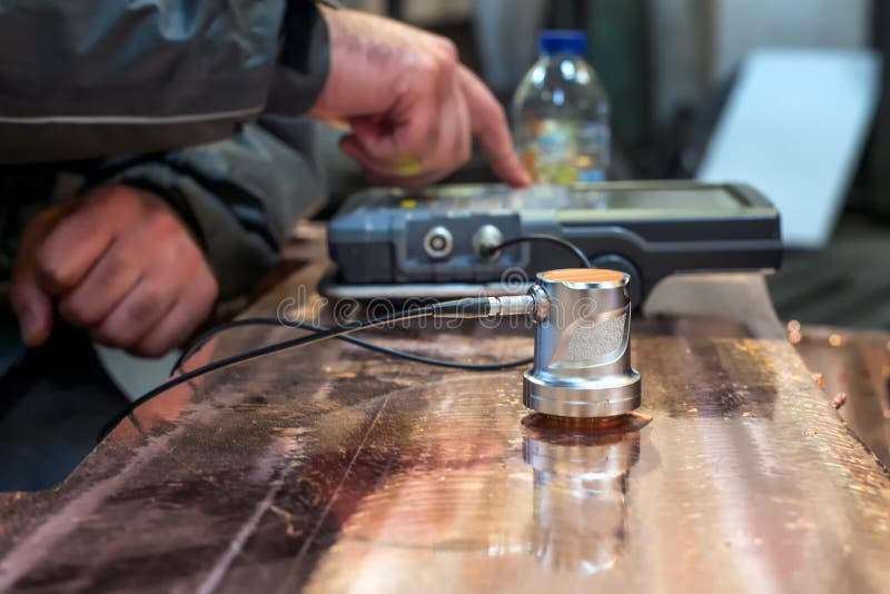 Ultraljudstest eller ultraljudstest av koppargjutmaterial. Ett vanligt exempel är mätning av ultraljudstjocklek. arkivfoto