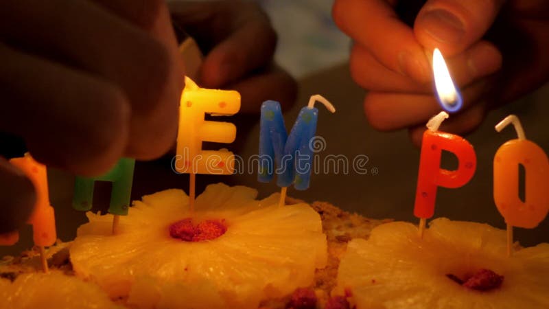 Ultrarapidcloseupfolket tänder stearinljus på födelsedagkakan
