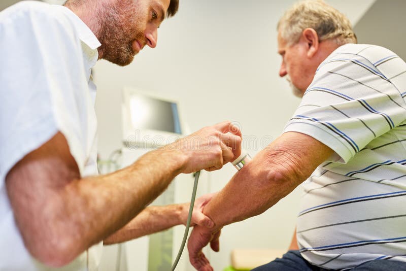 Female Doctor with Senior at Electrotherapy for Pain Relief Stock