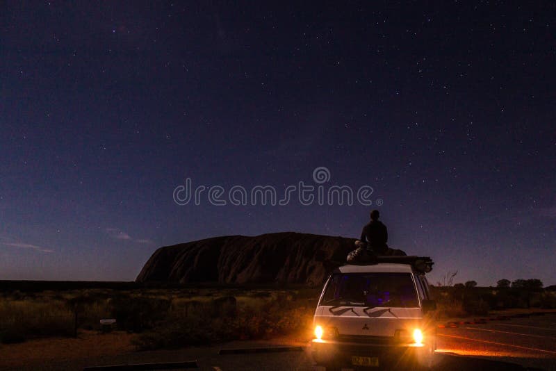 Uluru at night with car with a young man on the car, ayers Rock, the Red Center of Australia, Australia royalty free stock images Uluru at night with car with a young man on the car, ayers Rock, the Red Center of Australia, Australia royalty free stock images