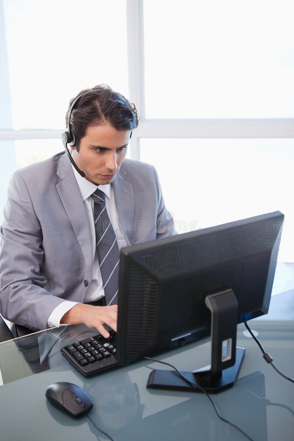 Um assistente das vendas que trabalha com um monitor foto de stock Um assistente das vendas que trabalha com um monitor foto de stock