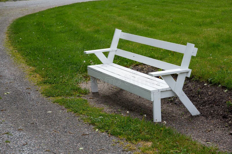 Um banco de madeira num parque com grama verde. fotografia de stock royalty free