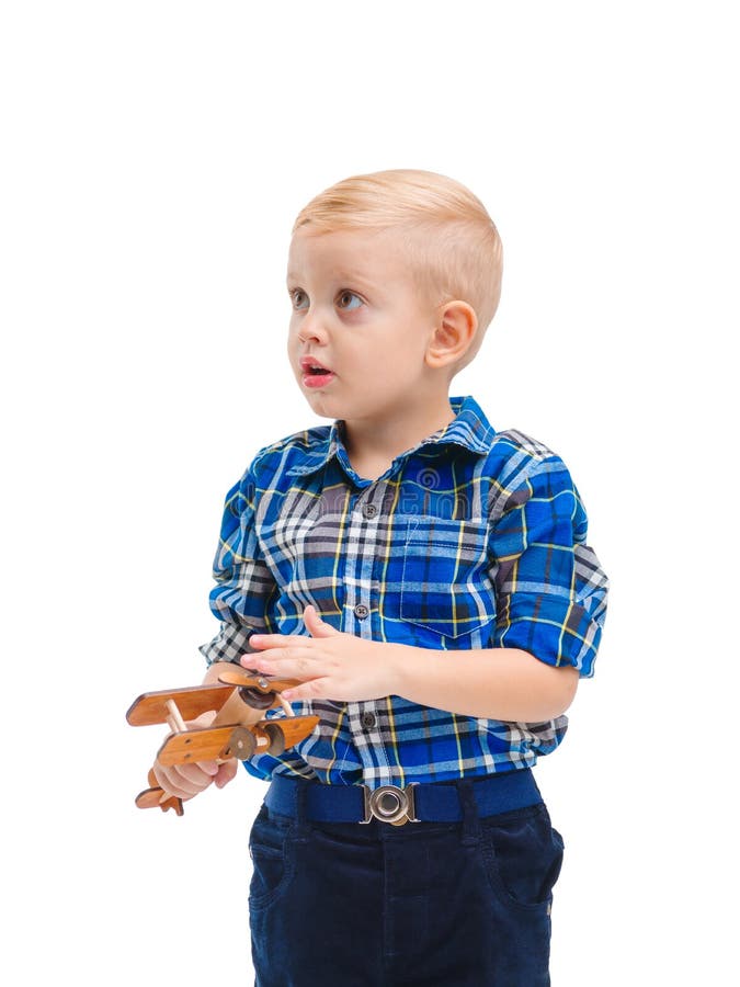 Um bebê bonito, olhares interessados de lado e posses um avião do brinquedo em suas mãos Isolado no branco fotos de stock Um bebê bonito, olhares interessados de lado e posses um avião do brinquedo em suas mãos Isolado no branco fotos de stock