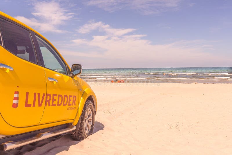 Um carro amarelo do quatro rodas motrizes para as salvas-vidas em um dani ensolarado imagem de stock Um carro amarelo do quatro rodas motrizes para as salvas-vidas em um dani ensolarado imagem de stock