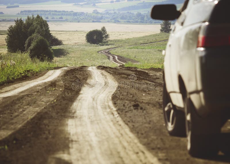 Um carro ao lado de uma estrada de terra do enrolamento foto de stock Um carro ao lado de uma estrada de terra do enrolamento foto de stock