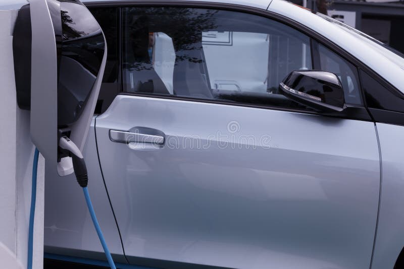 Um carro elétrico obstruído dentro para recarregar as baterias imagem de stock Um carro elétrico obstruído dentro para recarregar as baterias imagem de stock