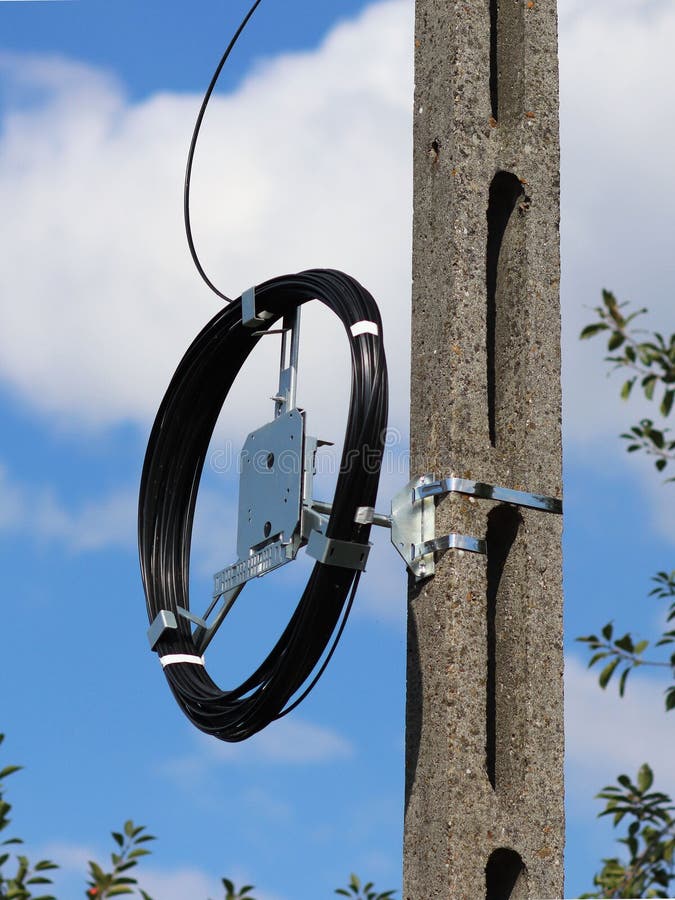 Um chicote de fios de cabo de fibra ótica para uma comunicação pesa em uma coluna concreta Telecomunicações e Internet Repare o t foto de stock royalty free Um chicote de fios de cabo de fibra ótica para uma comunicação pesa em uma coluna concreta Telecomunicações e Internet Repare o t foto de stock royalty free
