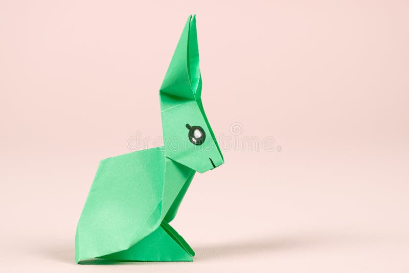 Coelhinhos da páscoa feitos à mão de papel colorido, artesanato fácil para  crianças em um fundo verde.