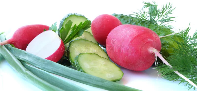 A set of basic ingredients for preparing a vitamin salad on a light background. The set of vegetables includes radish and cucumber. Chicken eggs, spring onions, parsley and dill are usually added to the vegetable salad, everything is finely chopped and greased with vegetable oil, ground black pepper, salt, and spices are added to taste. Red and green colors predominate. A set of basic ingredients for preparing a vitamin salad on a light background. The set of vegetables includes radish and cucumber. Chicken eggs, spring onions, parsley and dill are usually added to the vegetable salad, everything is finely chopped and greased with vegetable oil, ground black pepper, salt, and spices are added to taste. Red and green colors predominate.