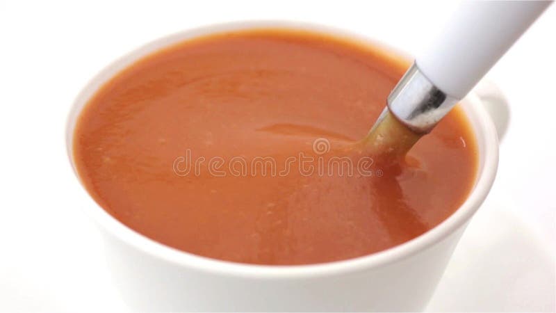 Um copo da sopa do tomate que está sendo agitada