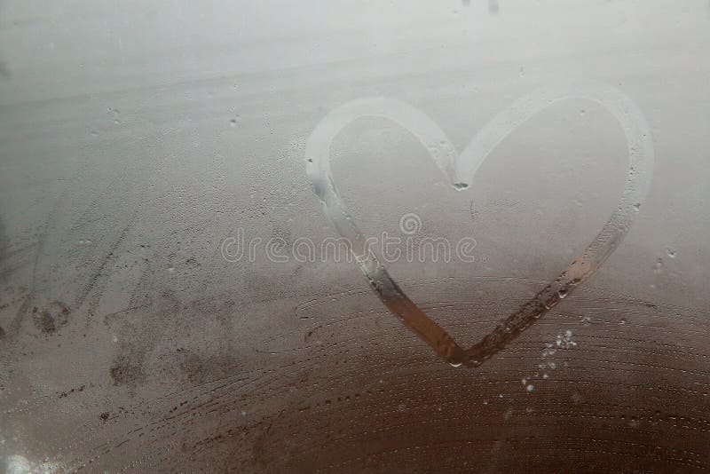 Um coração pintado em uma janela misted Coração no vidro misted Coração em um fundo da janela foto de stock royalty free Um coração pintado em uma janela misted Coração no vidro misted Coração em um fundo da janela foto de stock royalty free