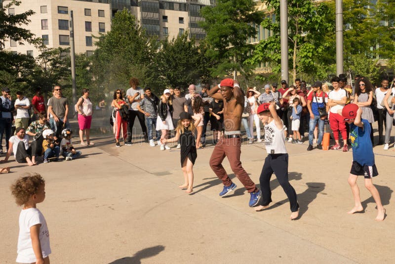 Um dançarino da rua que faz uma mostra da dança em uma rua de Paris, usando crianças no público imagem de stock Um dançarino da rua que faz uma mostra da dança em uma rua de Paris, usando crianças no público imagem de stock
