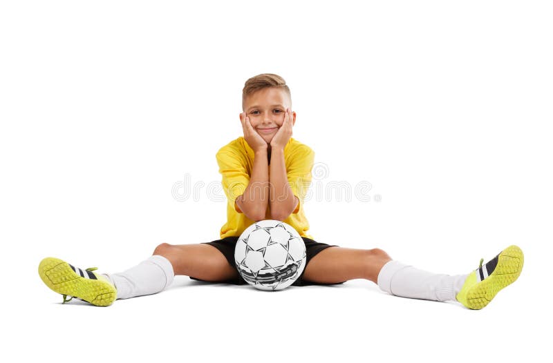 Um desportista novo bonito em um t-shirt amarelo e em um short preto que sentam-se em um assoalho isolado em um fundo branco fotografia de stock royalty free Um desportista novo bonito em um t-shirt amarelo e em um short preto que sentam-se em um assoalho isolado em um fundo branco fotografia de stock royalty free