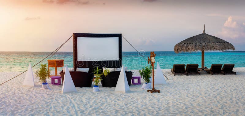 Um evento privado de cinema a céu aberto criado numa praia tropical