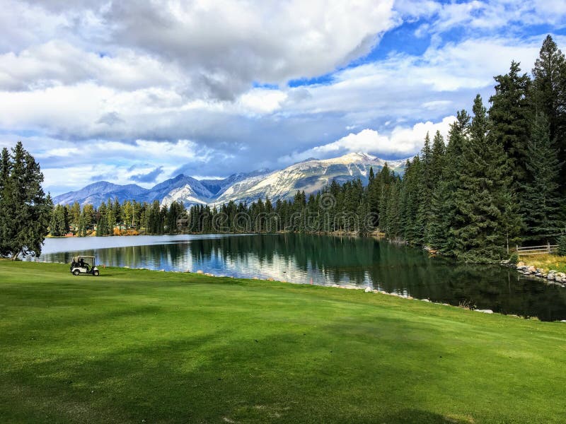 Um furo bonito do golfe no jaspe, Alberta, elevação nas montanhas de Montanhas Rochosas O fairway é ao lado de um lago bonito foto de stock royalty free Um furo bonito do golfe no jaspe, Alberta, elevação nas montanhas de Montanhas Rochosas O fairway é ao lado de um lago bonito foto de stock royalty free