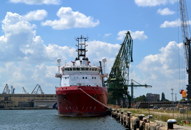 Um grande navio de carga do mar vermelho e branco em um porto fotos de stock Um grande navio de carga do mar vermelho e branco em um porto fotos de stock