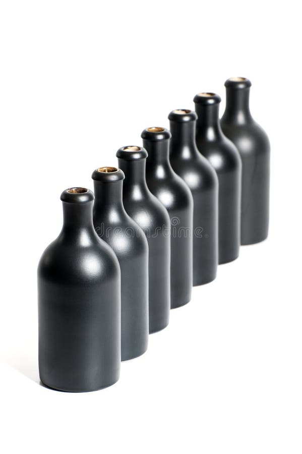Um grupo de diversas garrafas pretas vazias em um fim branco do fundo imagem de stock Um grupo de diversas garrafas pretas vazias em um fim branco do fundo imagem de stock