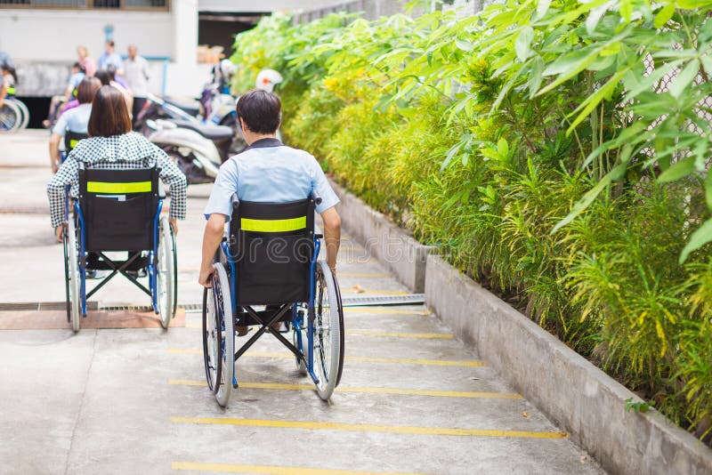 Um grupo de pessoas com a cadeira de rodas na estrada