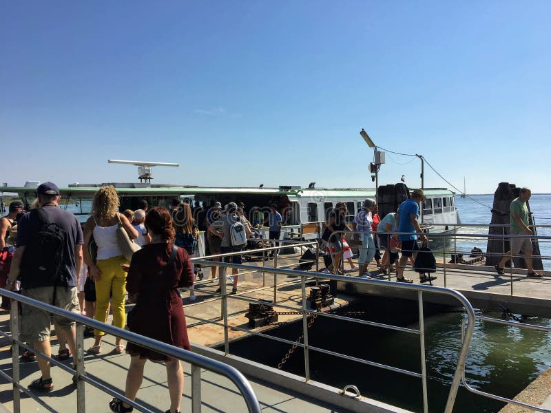 Um grupo de pessoas que espera para embarcar uma balsa ou um vaporetto da água na ilha de Murano, apenas acima de Veneza, Itália, imagem de stock Um grupo de pessoas que espera para embarcar uma balsa ou um vaporetto da água na ilha de Murano, apenas acima de Veneza, Itália, imagem de stock