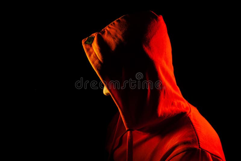 Um homem adulto está o olhar ao lado em uma camiseta encapuçado alaranjada destacada em vermelho e amarelo nos lados sua cara é c imagem de stock royalty free Um homem adulto está o olhar ao lado em uma camiseta encapuçado alaranjada destacada em vermelho e amarelo nos lados sua cara é c imagem de stock royalty free