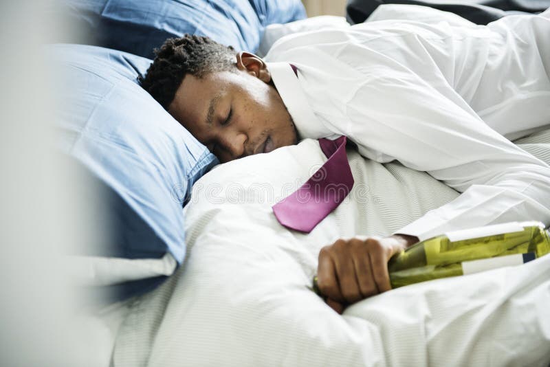 Um homem bêbado que passa para fora na cama foto de stock Um homem bêbado que passa para fora na cama foto de stock