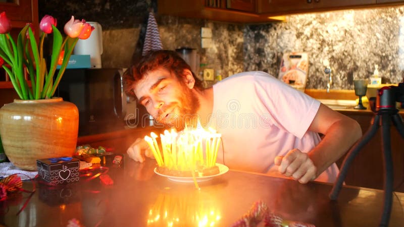 Um homem de 36 anos acende velas em um bolo. quer soprar velas, mas não sopram