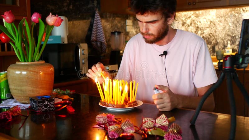 Um homem de 36 anos acende velas em um bolo. quer soprar velas, mas não sopram