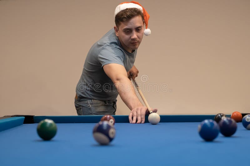 Bolas de bilhar na mesa de bilhar com as mãos e pau do jogador o