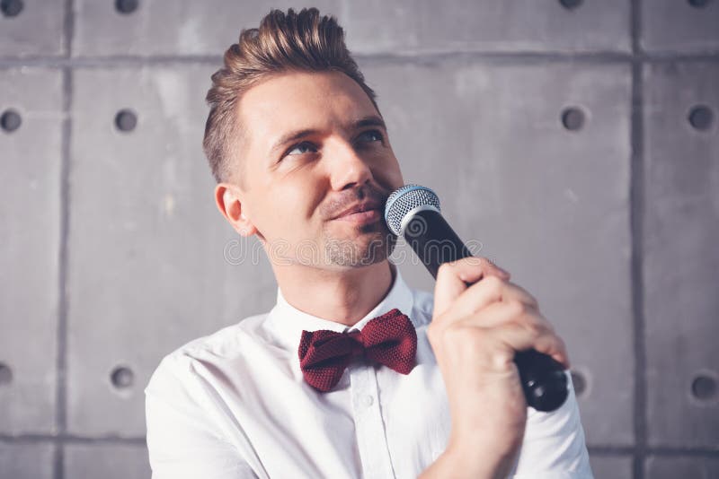 Um homem emocional alegre engraçado atrativo novo pisc em um s branco foto de stock Um homem emocional alegre engraçado atrativo novo pisc em um s branco foto de stock