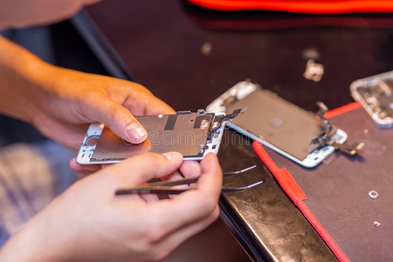 Um homem está consertando um celular No quadro, suas mãos e detalhes do dispositivo oficina de reparo para gadgets