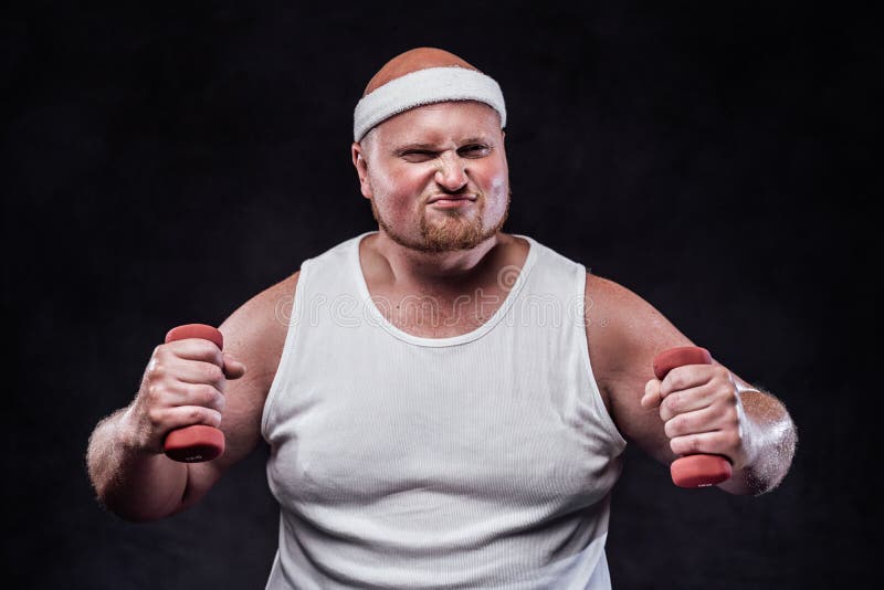Burly man in a white tracksuit holds dumbbells in his hands and very tensely looks directly at the camera. Burly man in a white tracksuit holds dumbbells in his hands and very tensely looks directly at the camera