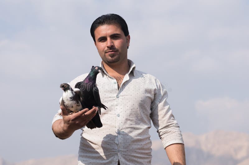 Um homem que guarda pombos com orgulho fotografia de stock royalty free