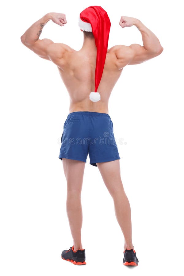 Um indivíduo atlético com um torso despido e um chapéu de Santa, suportes com o seu suporta e mostras seu bíceps imagens de stock royalty free Um indivíduo atlético com um torso despido e um chapéu de Santa, suportes com o seu suporta e mostras seu bíceps imagens de stock royalty free