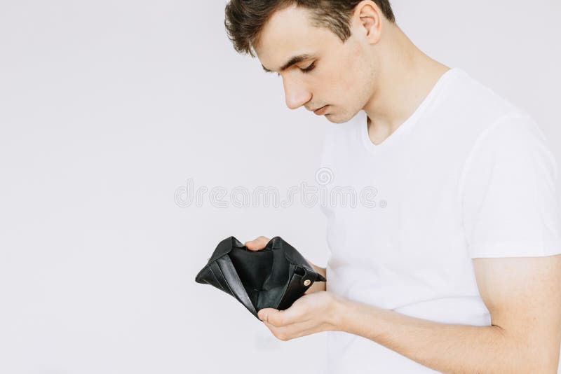 Um indivíduo novo olha em uma carteira vazia Fundo branco isolado imagem de stock Um indivíduo novo olha em uma carteira vazia Fundo branco isolado imagem de stock