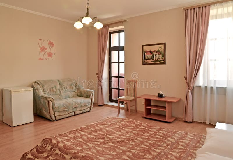 Um interior do hotel rr da sala de hotel em tons cor-de-rosa com uma saída a um balcão Clássicos modernos imagem de stock royalty free Um interior do hotel rr da sala de hotel em tons cor-de-rosa com uma saída a um balcão Clássicos modernos imagem de stock royalty free