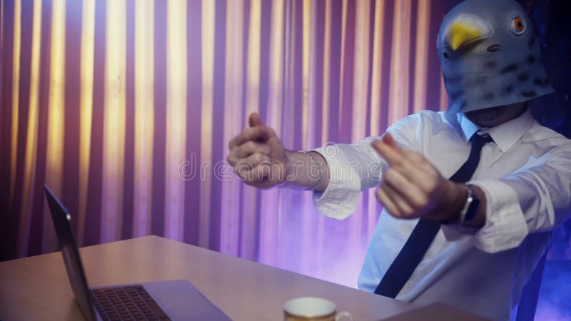 Um Jovem Com Máscara De Pombo Está Sentado Em Uma Cadeira Na Mesa