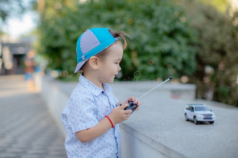 Um Menino Brinca Com Um Carro De Brinquedo No Rádio Segurando Um Controle  Remoto Imagem de Stock - Imagem de humano, jogar: 176431403