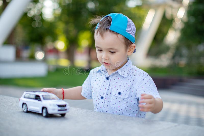 Um Menino Brinca Com Um Carro De Brinquedo No Rádio Segurando Um Controle  Remoto Imagem de Stock - Imagem de humano, jogar: 176431403