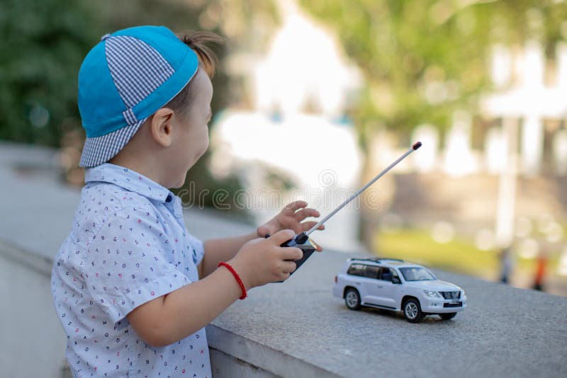 Um Menino Brinca Com Um Carro De Brinquedo No Rádio Segurando Um Controle  Remoto Imagem de Stock - Imagem de humano, jogar: 176431403