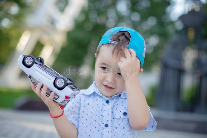 Um Menino Brinca Com Um Carro De Brinquedo No Rádio Segurando Um Controle  Remoto Imagem de Stock - Imagem de humano, jogar: 176431403