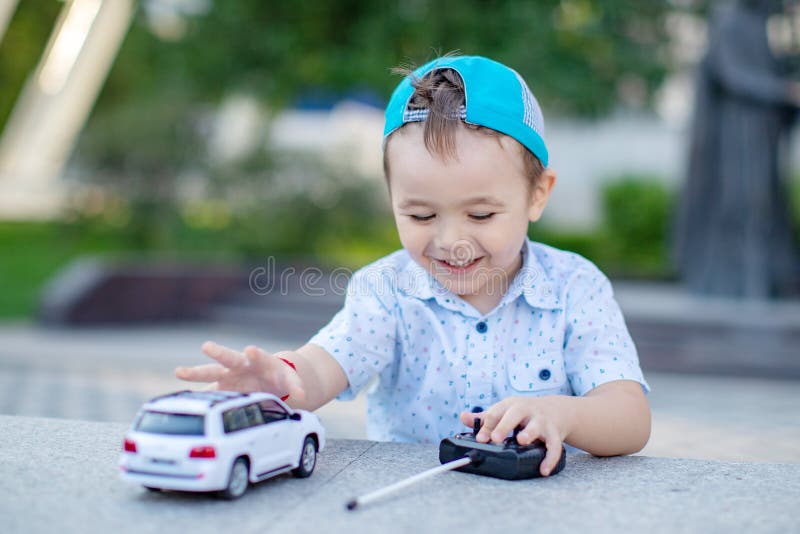 Um Menino Brinca Com Um Carro De Brinquedo No Rádio Segurando Um Controle  Remoto Imagem de Stock - Imagem de humano, jogar: 176431403